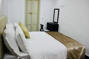 a bedroom with a bed with white sheets and pillows at DAR Riad Jomana in Marrakech