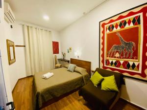 a bedroom with a bed and a couch in it at Marco Polo Party Hostel in St. Julianʼs