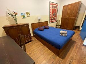 a bedroom with a bed with blue sheets and a table at Marco Polo Party Hostel in St. Julianʼs