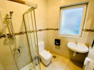 a bathroom with a toilet and a sink and a window at Marco Polo Party Hostel in St. Julianʼs