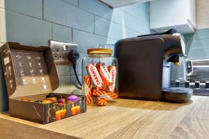 a jar of candy on a counter next to a toaster at Deluxe king seaside apartment in Bare