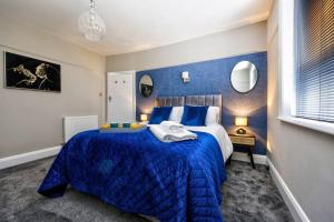 a blue and white bedroom with a large bed at Deluxe king seaside apartment in Bare