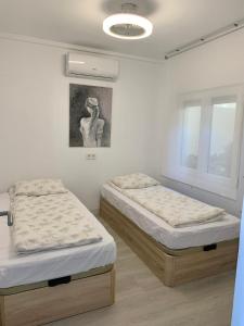 sypialnia z 2 łóżkami i obrazem na ścianie w obiekcie Holiday house Torrevieja w mieście Torrevieja