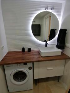 a bathroom with a washing machine and a mirror at Piso pl 2A, 20 min Plaza Cataluña in Sant Adria de Besos