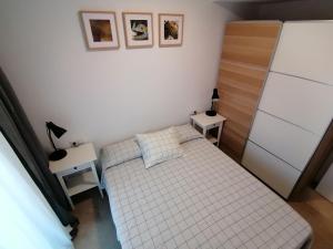 a small bedroom with a bed and a refrigerator at Piso pl 2A, 20 min Plaza Cataluña in Sant Adria de Besos