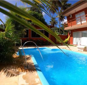 嘎林海斯港的住宿－Pousada Recanto Pontal de Maracaipe，一座大型蓝色游泳池,位于房子旁边