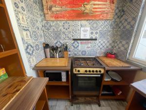 a small kitchen with a stove and a microwave at Marco Polo Party Hostel in St. Julianʼs