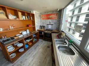 a small kitchen with a sink and a window at Marco Polo Party Hostel in St. Julianʼs