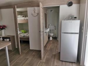 a small room with a refrigerator and a bedroom at Mediterranean mobile homes - Lotty in Drage