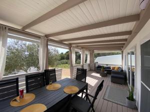 a porch with a table and chairs on a deck at Mediterranean mobile homes - Lotty in Drage