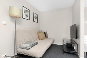 a bedroom with a bed with a lamp and a tv at Central Studio Apartment in Stavanger in Stavanger