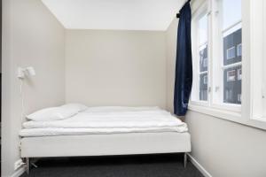 Cama en habitación con ventana en Central Studio Apartment in Stavanger, en Stavanger