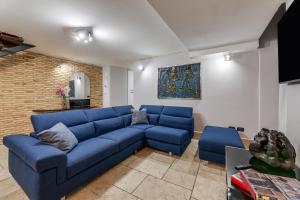 um sofá azul numa sala de estar com uma parede de tijolos em Oliviero - Piazza Navona Apartment em Roma