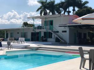 a house with a swimming pool next to a building at La Bella Vista in Calarcá