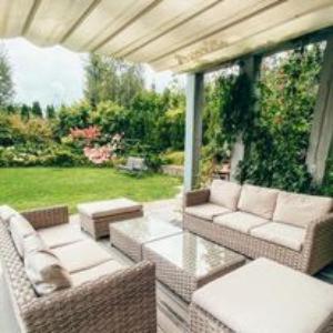 ミコワイキにあるVilla Melaの籐家具付きのパティオから庭の景色を望めます。