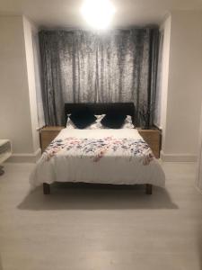 a bedroom with a bed with a black headboard at Dream Nest in Southend-on-Sea