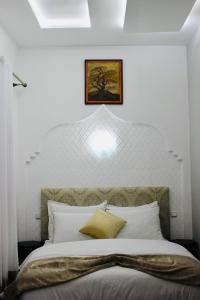 a bedroom with a large bed with a white headboard at DAR Riad Jomana in Marrakech
