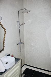 a bathroom with a white sink and a shower at DAR Riad Jomana in Marrakech
