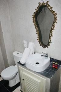 a bathroom with a sink and a toilet and a mirror at DAR Riad Jomana in Marrakech