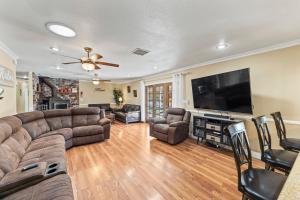 a living room with a couch and a flat screen tv at Spacious Desert Getaway! 1-Story, 5BR, 3 Master Suites, Casita, Pool, EV, Game Room in Las Vegas