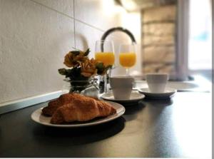 una mesa con un plato de comida y dos vasos de zumo de naranja en Apartment near Colloseum en Pula