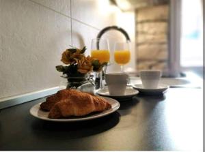 Una mesa con un plato de comida y dos vasos de jugo de naranja. en Apartment near Colloseum, en Pula 7 fotos más
