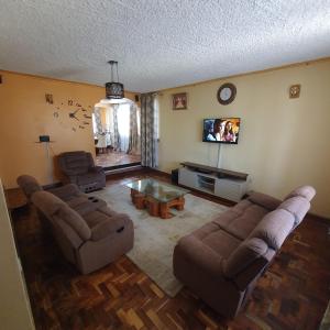 a living room with two couches and a tv at Château Lake-ish in Nakuru