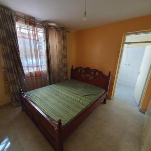 um quarto com uma cama num quarto com uma janela em Château Lake-ish em Nakuru