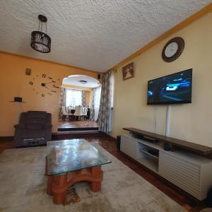 a living room with a coffee table and a flat screen tv at Château Lake-ish in Nakuru