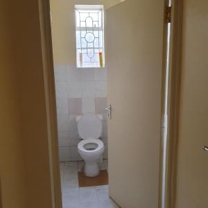 a bathroom with a toilet and a window at Château Lake-ish in Nakuru