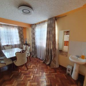 um quarto com uma mesa e cadeiras e um lavatório em Château Lake-ish em Nakuru