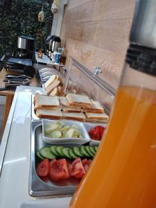 ミラーノにあるLa Casa di Lindaのカウンターにサンドイッチと野菜のトレイを用意しています。