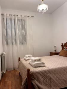 um quarto com uma cama com lençóis brancos e um lustre em Casa de Sergude em Peso da Régua
