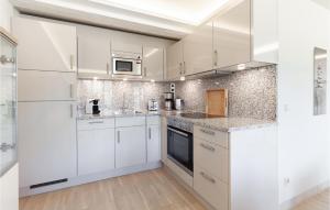 a white kitchen with white cabinets and appliances at Cloud in Binz