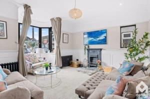 a living room with two couches and a fireplace at Victorian Town House central Cheltenham in Cheltenham