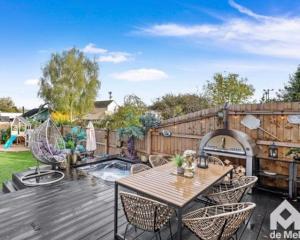 a backyard with a wooden deck with a table and chairs at Victorian Town House central Cheltenham in Cheltenham
