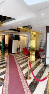 a lobby with a red carpet and a red ribbon at السهم الذهبي للشقق المخدومة in Taif