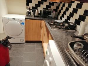 a small kitchen with a stove and a dishwasher at Spacious Room near Manchester City Centre in Manchester