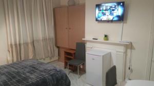 a bedroom with a bed and a tv on the wall at Spacious Room near Manchester City Centre in Manchester