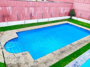 an empty swimming pool in front of a pink fence at Apartamentos Ruta da Auga in Ribadumia