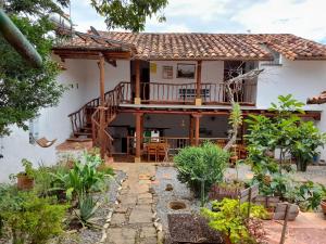 a house with a deck and a patio at Posada Sueños de Antonio in Barichara