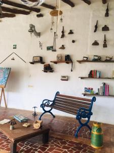 um banco e uma mesa numa sala com prateleiras em Posada Sueños de Antonio em Barichara