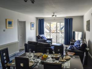 uma sala de estar com sofás, uma mesa e cadeiras em Apartment 15 Harvest Moon em Newquay