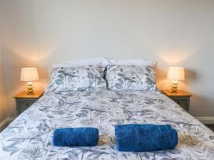 uma cama com duas almofadas azuis com dois candeeiros em Apartment 15 Harvest Moon em Newquay