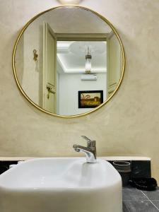 a bathroom with a white sink and a mirror at DAR Riad Jomana in Marrakech