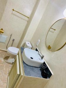 a bathroom with a sink and a toilet and a mirror at DAR Riad Jomana in Marrakech
