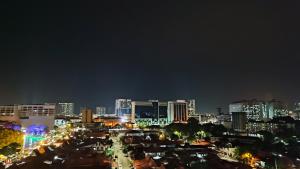 una ciudad iluminada por la noche con edificios en The Honeymoon Haven - 99 Residences, en Melaka