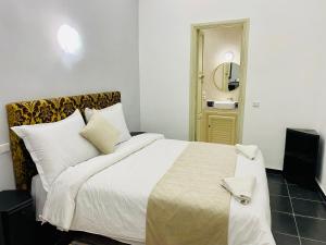 um quarto com uma cama grande e um espelho em DAR Riad Jomana em Marraquexe