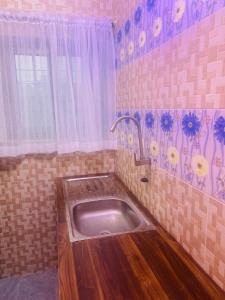 a kitchen with a sink in a tiled bathroom at Emefa Room in Cotonou