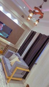 Emefa Room في كوتونو: غرفة بسرير وتلفزيون بشاشة مسطحة